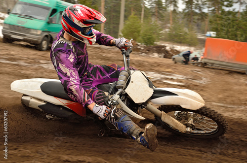 Motocross athlete raised leg forward executes turning photo