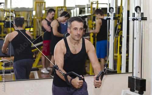 Middle aged man working out with gym equipment