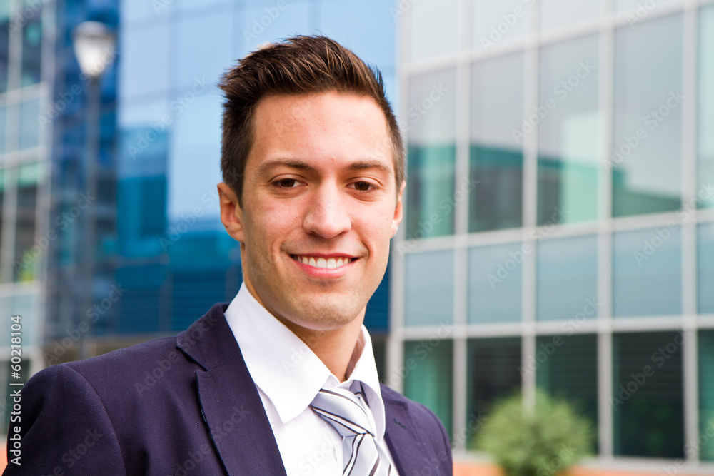 Smiling young businessman standing outside a building Smiling young businessman standing outside a building
