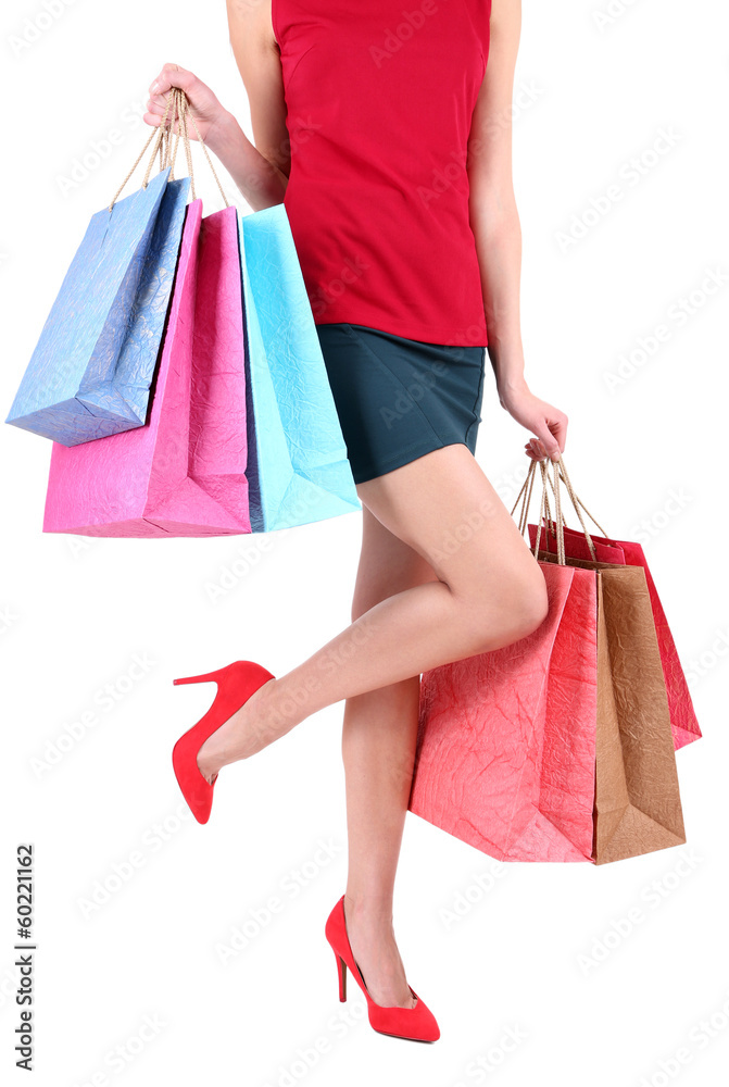Female in red shoes holding shopping bags isolated on white