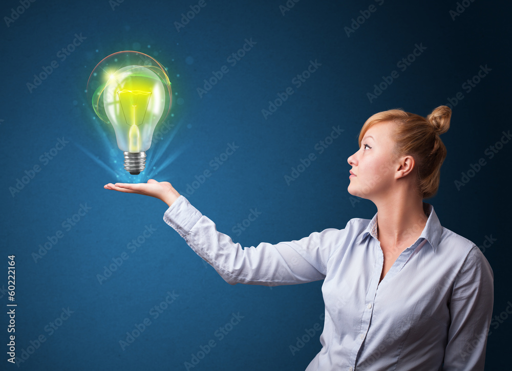 Glowing lightbulb in the hand of a businesswoman Glowing lightbulb in the hand of a businesswoman
