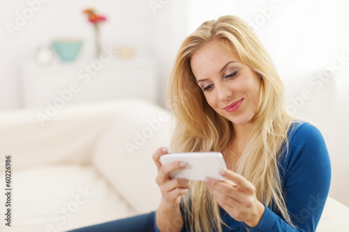 Beautiful woman with white mobile phone at living room