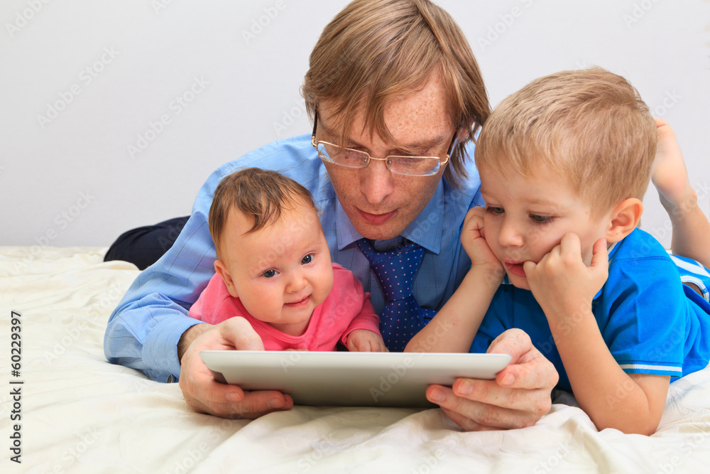 father of two kids in business style with touch pad father of two kids in business style with touch pad