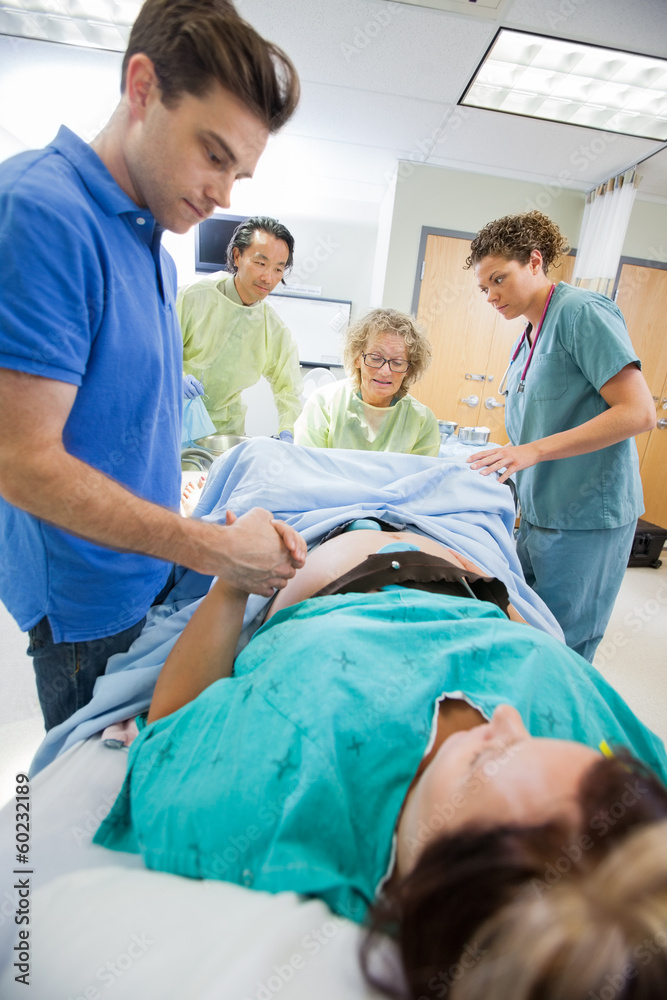 Man Holding Woman's Hand During Delivery In Hospital