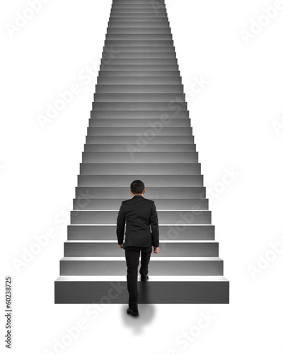 Rear view businessman climbing on stairs isolated in white