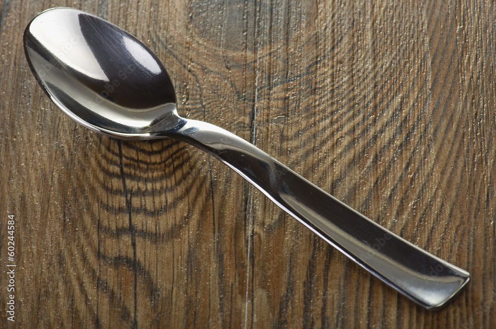 Iron spoon close up on the wooden table Iron spoon close up on the wooden table