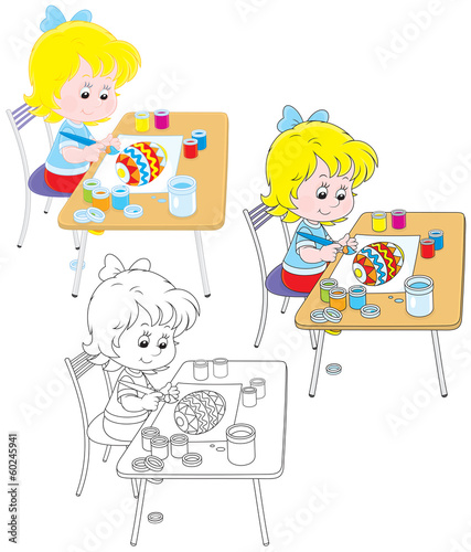 Little girl drawing a colorful Easter egg