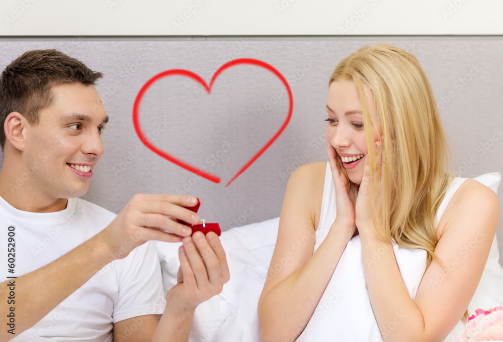 man giving woman little red box and ring in it man giving woman little red box and ring in it