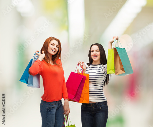 two smiling teenage girls with shopping bags