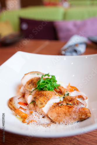 Chicken breast with baby vegetables on plate