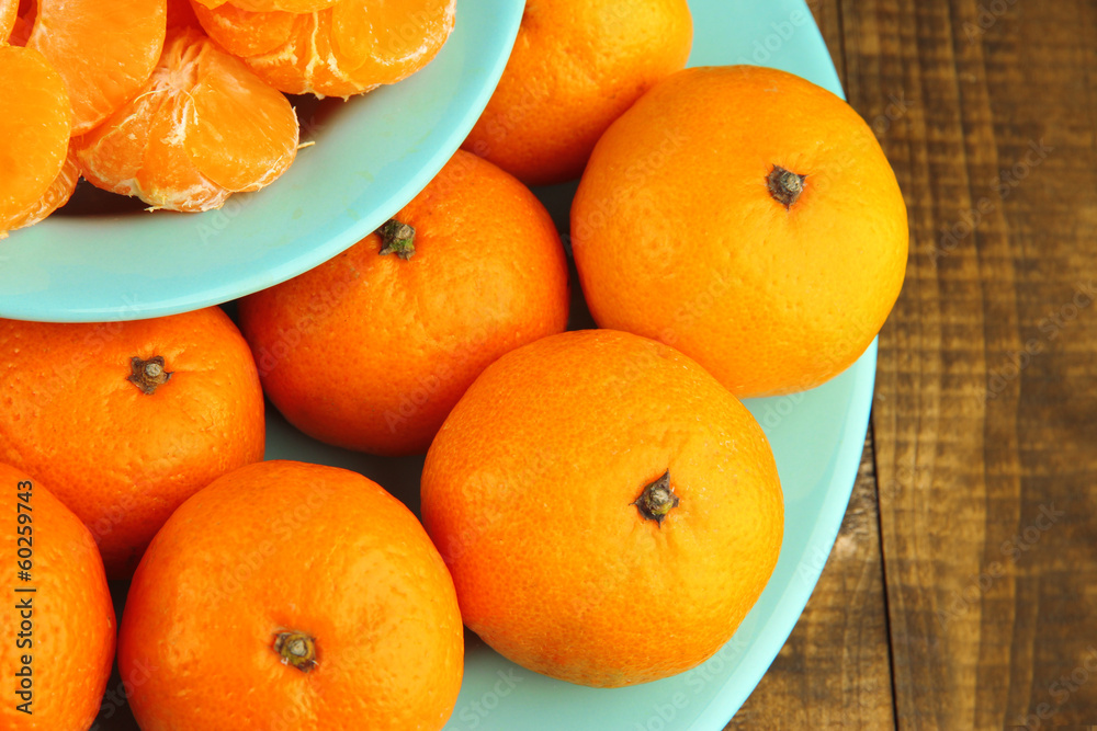 Ripe tangerines in bowl on wooden background Ripe tangerines in bowl on wooden background