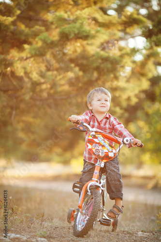 Happy boy on a bicycle in a summer park