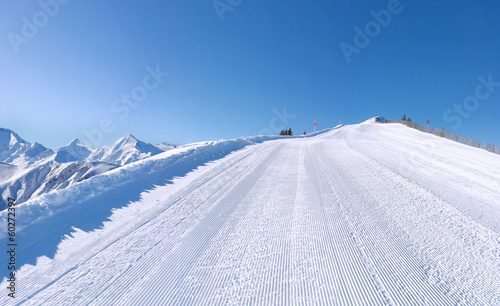 Perfectly groomed ski slope with mountains