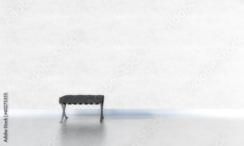 1 schwarzer Stuhl vor weißer Wand