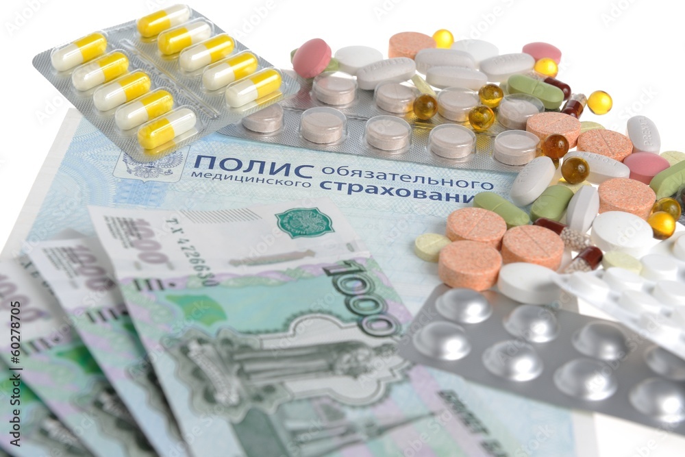 Таблетки и деньги на фоне медицинского полиса Таблетки и деньги на фоне медицинского полиса