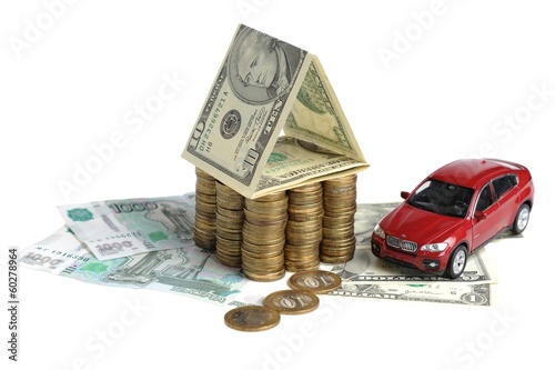 Дом из денег и автомобиль на купюрах на белом фоне