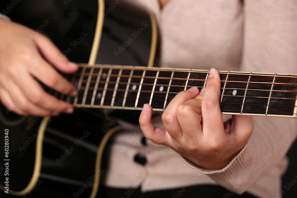 Acoustic guitar in female hands, close-up