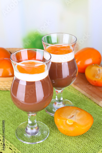 Dessert of chocolate and persimmon on table on light background