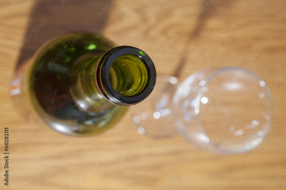 Wine Bottle and empty glass on a wooden table.