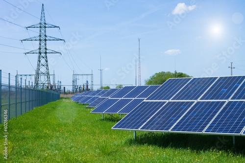 solar panel against high voltage tower photo