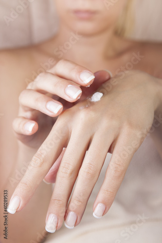 female applying cream on her hands
