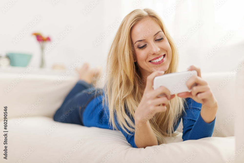 Woman relaxing on sofa with mobile phone Woman relaxing on sofa with mobile phone