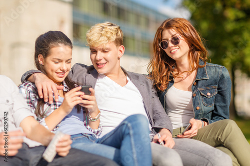 group of students or teenagers with smartphones