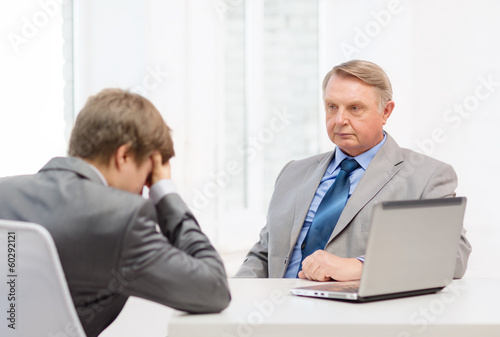 older man and young man having argument in office