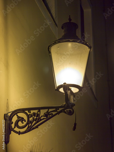 Beautiful, decorated lantern attached to the wal of an old house