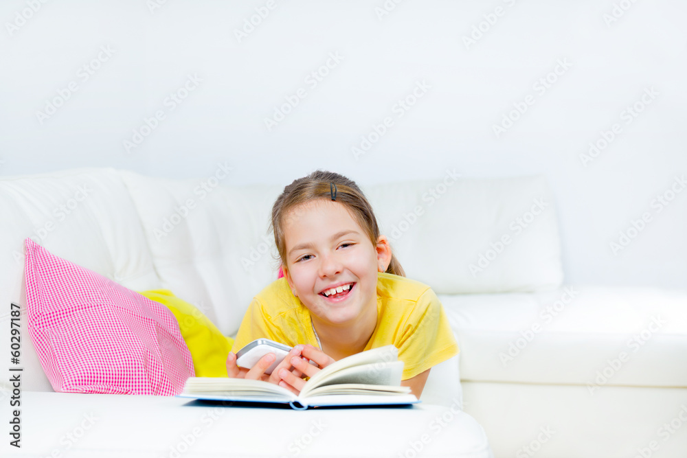 little girl with smart phone and book at home little girl with smart phone and book at home