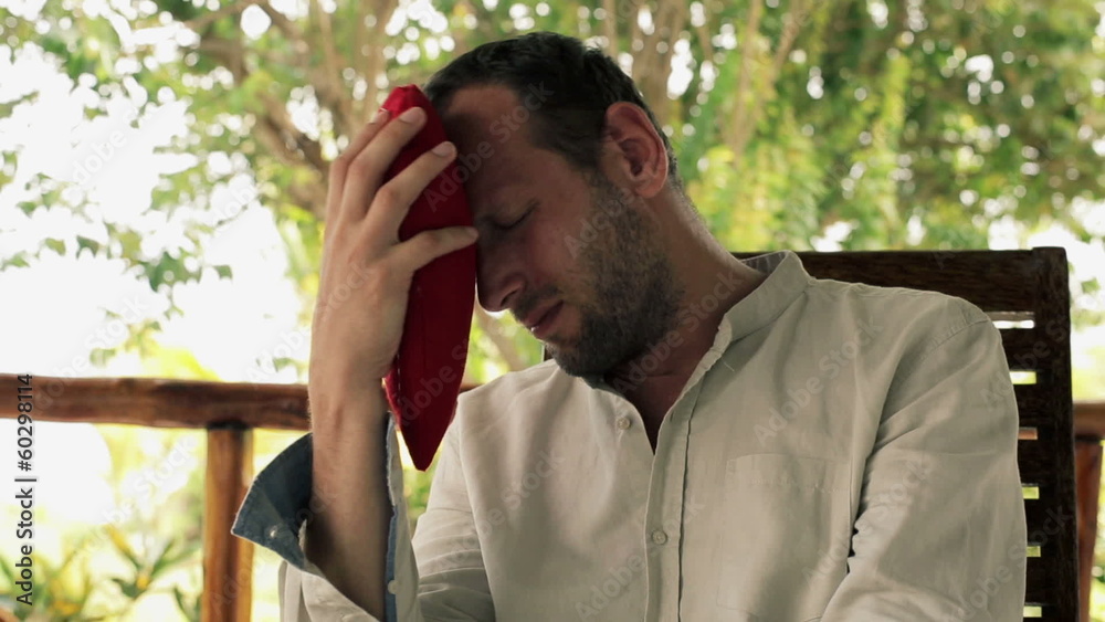 Despair, unhappy man with heart shape pillow on porch Despair, unhappy man with heart shape pillow on porch
