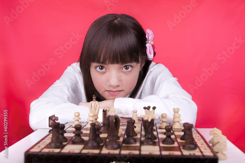 Girl looks at camera during chess.
