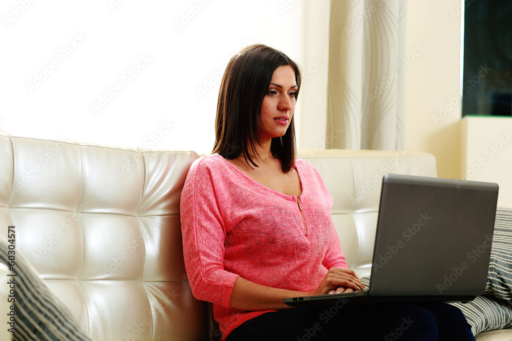 Young beautiful woman sitting on the sofa with laptop at home Young beautiful woman sitting on the sofa with laptop at home