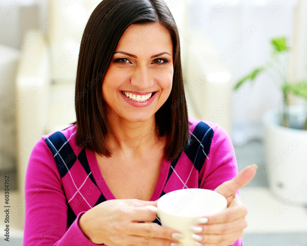 Portrait of a young cheerful woman holding cup of coffee Portrait of a young cheerful woman holding cup of coffee