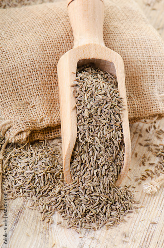Cumin seeds in wooden scoop