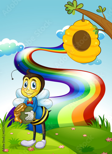 A hilltop with a rainbow and a bee near the beehive