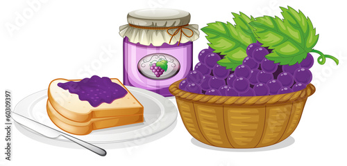 A basket of grapes, jam and a sandwich