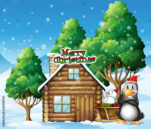 A penguin and a snowman beside the wooden house