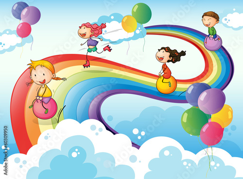 A group of kids playing at the sky with a rainbow