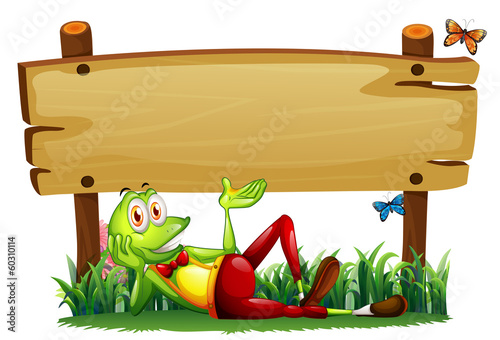 A playful frog under the empty wooden signboard