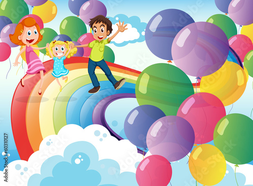 A happy family playing with the rainbow and the floating balloon