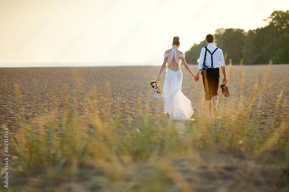 Bride and groom on a beach at sunset