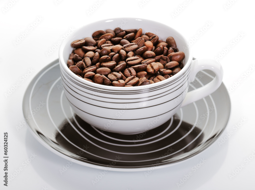 A cup full of coffee beans on a white background A cup full of coffee beans on a white background