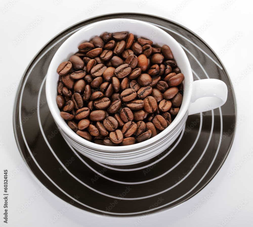 A cup full of coffee beans on a white background A cup full of coffee beans on a white background