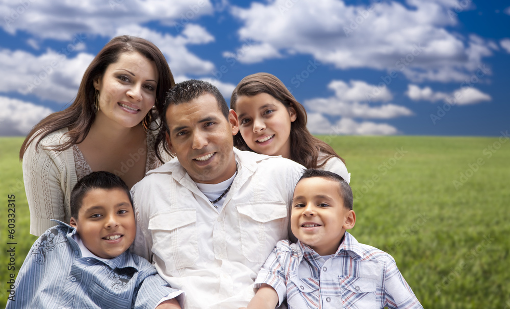 Hispanic Family Portrait Sitting in Grass Field Hispanic Family Portrait Sitting in Grass Field
