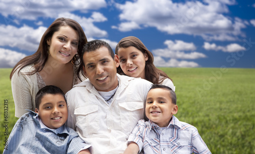Hispanic Family Portrait Sitting in Grass Field