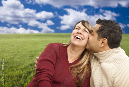 Happy Mixed Couple Sitting in Grass Field © Andy Dean