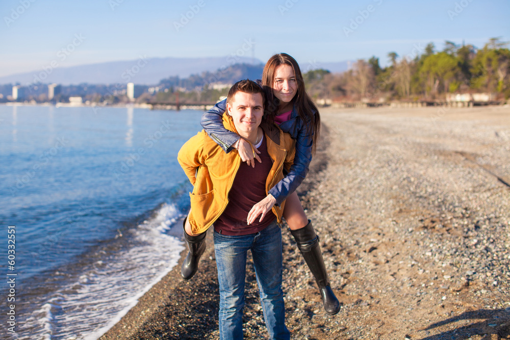 Happy couple having fun at the beach on a sunny fall day