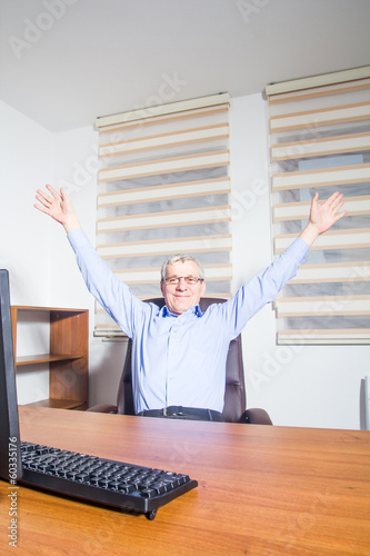 Senior man sitting at his office photo