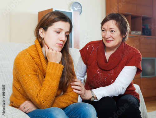 Sad woman and her mature mother having conflict photo